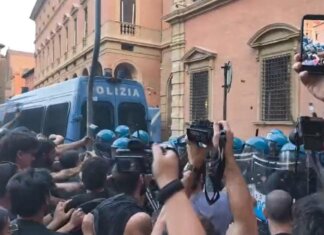 Morto ammanettato a Bologna, coro “assassini” e tensioni tra agenti e corteo: polizia usa idranti e lacrimogeni