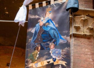 Palio di Siena 16 agosto, il Drappellone fa discutere: polemiche sul volto della Madonna ‘androgina’
